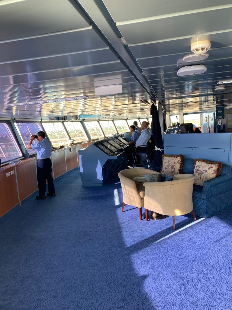 Navigational bridge of a cruise ship with lookout, pilot, ship's officers
